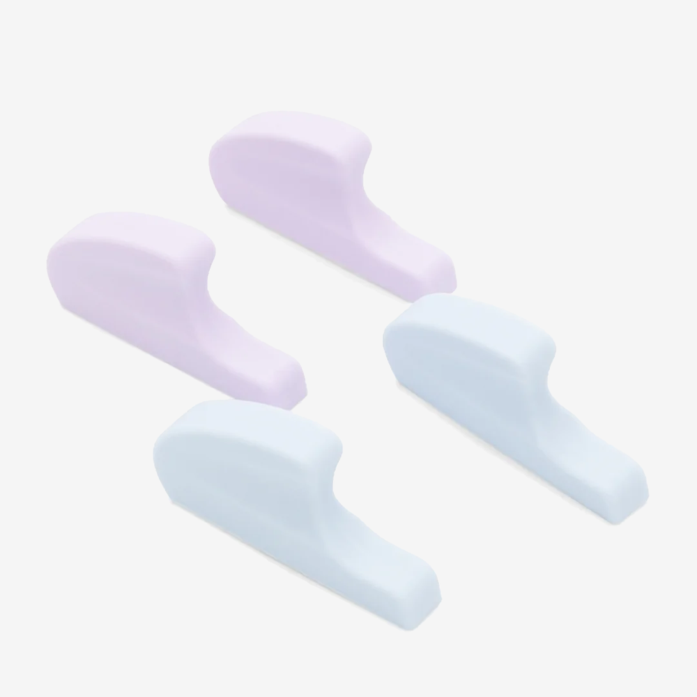 
                      
                        Four spacers, two lavender and two blue, sit upright against a plain light grey background.
                      
                    