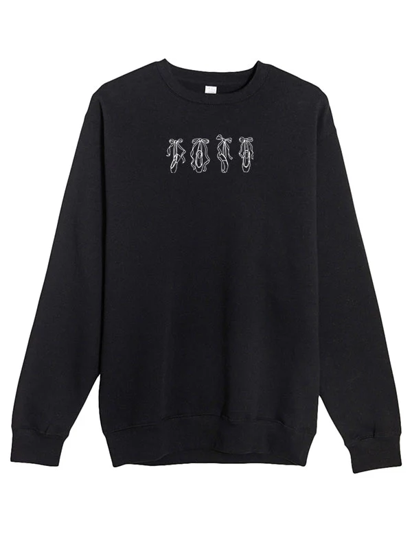 
                      
                        A black crewneck sweater with line art of four pointe shoes.
                      
                    