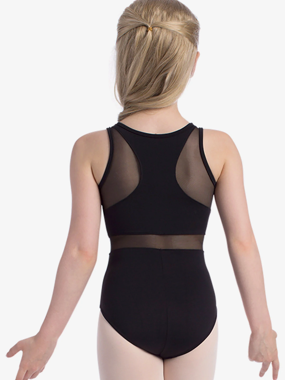 A young girl stands with her back to the camera, wearing a black tank leotard with mesh panels on the back and waist. She has long blonde hair styled in a half-up, half-down look and is positioned against a white background.